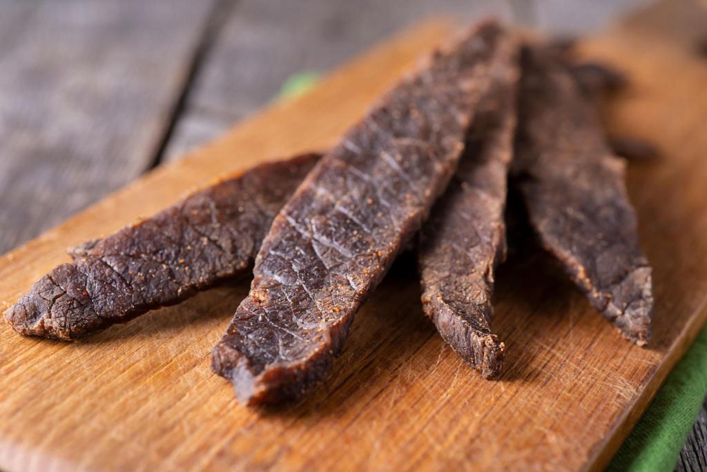 Bub's Jerky handcrafted beef jerky strips on a wooden cutting board
